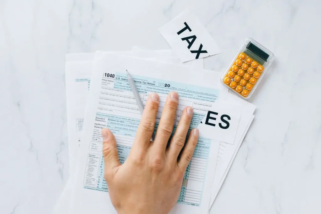 Person Working on Tax Documents with a Calculator