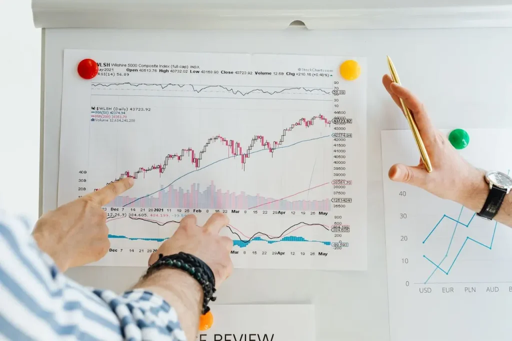 Three Professionals Analyse Stock Market Graphs 