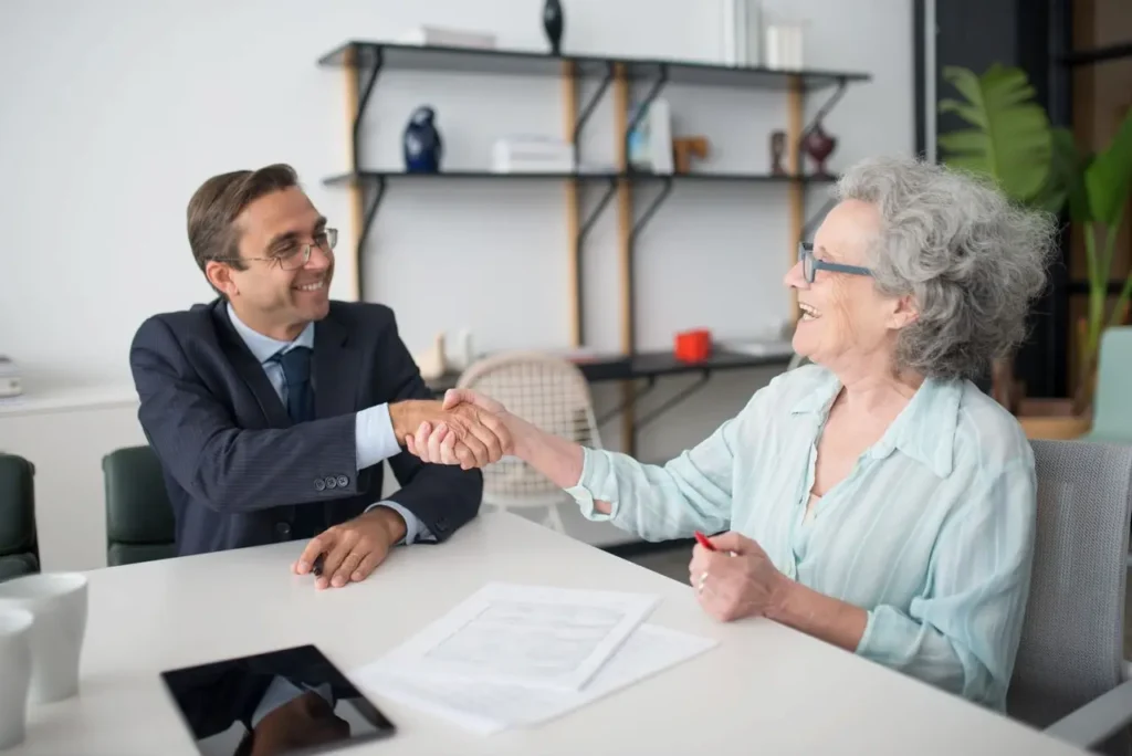 A Financial Advisor Shaking Hands with His Elderly Client 